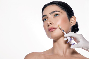 Cosmetologist doing beauty injection into nasolabial folds on female face with mimic wrinkles near...