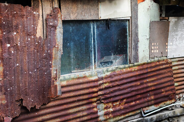Captivating shot highlighting aged corrugated iron, with rust tones, and window frame. The composition emphasizes decay and texture. Ideal for backgrounds; isolated in white background.