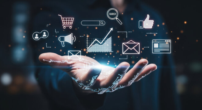 A person's hand projecting a holographic display of digital marketing icons, including a shopping cart, search bar, graph, megaphone, email, and social media...