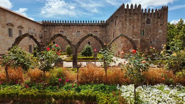 Santa Barbara Garden in Braga, Portugal flourishes beside the crenellated battlements of Braga Castle with bright parterres framing Gothic arches