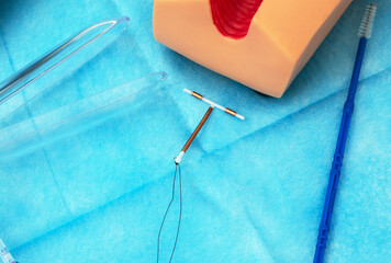 IUD. Experienced gynecologist showing female patient intrauterine contraceptive device or coil to...