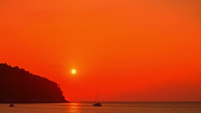 Time lapse Waves kiss the sandy beach while the fading sunlight creates a warm, romantic glow over the horizon. Serene Paradise Sunset by the Sea at Kala island Layan beach Phuket