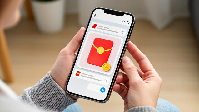 A person holds a smartphone displaying an app with a notification of a digital red envelope. The image represents the modern way of celebrating traditions and digital finance.