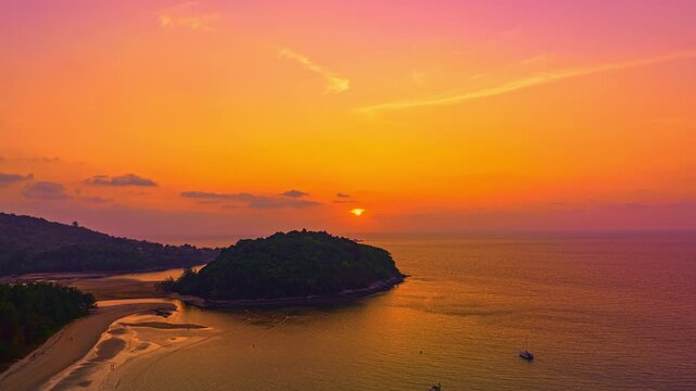 Aerial hyper lapse view of A stunning seascape capturing the vibrant colors of a dramatic sunset sky over a calm beach, Picturesque Tropical Sky at Sunset at Kala island Layan beach Phuket