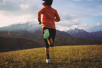 Trail runner running on the high altitude grassland mountain top