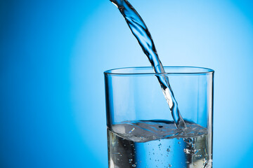Water pouring from water bottle to glass