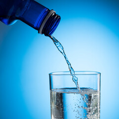Water pouring from water bottle to glass