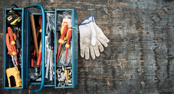 An open tool box photographed from above with many different tools in it.