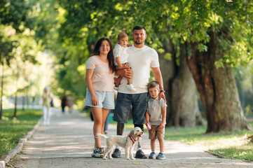 Fototapeta premium Smiling, enjoying the walk. Family of father that is amputee with prosthesis, mother and two kids