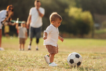Mother, amputee father with prosthesis and kids are on the field