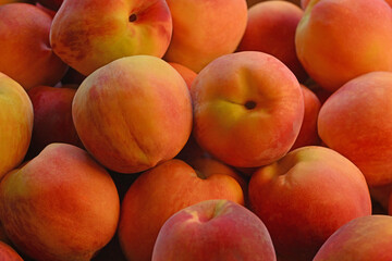 A bunch of peaches are piled on top of each other