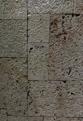 Rough textured stone wall detail with rectangular blocks and natural porous surface