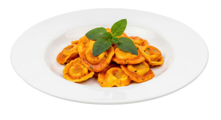 Isolated plate of cooked tortellini pasta with sauce and fresh basil herb on top, closeup