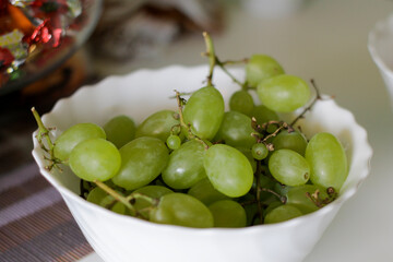 A bountiful display of fresh, vibrant green grapes in an elegant white serving bowl