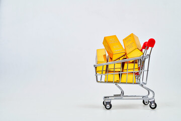 Gold bars in shopping cart isolated on white background Gold price rising all time high, high demand purchasing