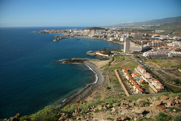 Obraz premium Panoramic aerial view of a vibrant coastal town and bustling harbor under a clear blue sky