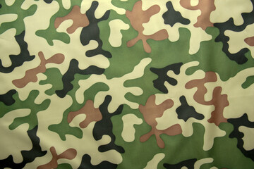 Fototapeta premium Close-up of a textile with a classic woodland-style camouflage pattern featuring natural earth tones and organic shapes