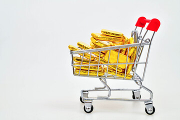 Gold bars in shopping cart isolated on white background Gold price rising all time high, high demand purchasing