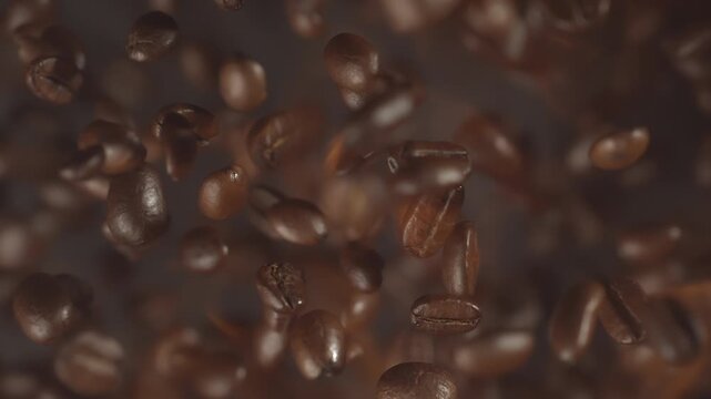 Super slow motion shot of falling roasted coffee beans with smoke in macro. Roasting hot flying coffee with fire. Burning whole coffee explosion close up vertical video