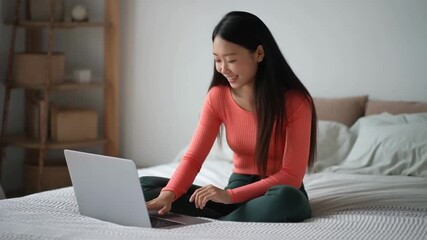 Beautiful young asian woman sitting on bed using laptop computer working from home in the bedroom, female is freelance using notebook online, one person, business and lifestyles concept