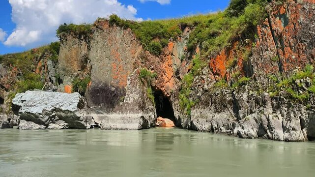 Skeleton Grotto in the coastal cliffs of the Katun River in Altai. Slow motion of a cave with a human skeleton hanging in it.