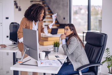 Office confrontation between two colleagues discussing performance issues in a modern workspace during a workday