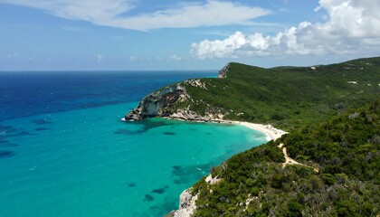 Obraz premium A breathtaking coastal view of a secluded bay, surrounded by lush green hills and a vibrant turquoise ocean.