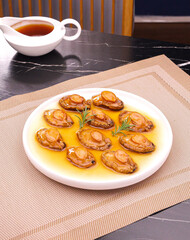 Stir-fried abalone and cucumber wrapped in golden sauce - Chinese seafood delicacy with tea