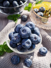 Fresh Organic Blueberries in Glass Bowl with Mint on Rustic Wood Background