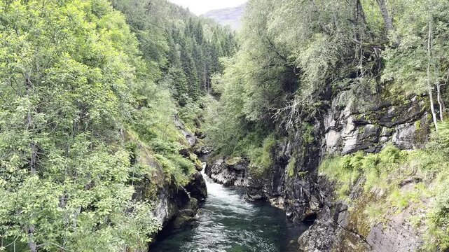 The river flows among the rocks of the mountains near hellesylt