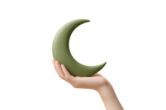 Female hand holding green crescent moon against black background, cut out