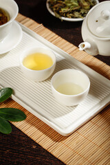 Chinese Tea Ceremony Set with White Porcelain Teapot and Cups on Bamboo Mat