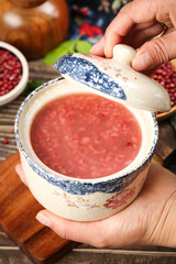 Red bean congee porridge in traditional ceramic pot with mixed grains healthy Asian comfort food