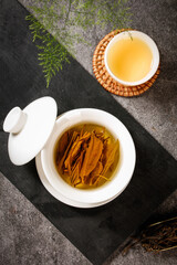 Freshly Brewed Green Tea Longjing Leaves in White Teapot with Traditional Chinese Tea Ceremony Setup