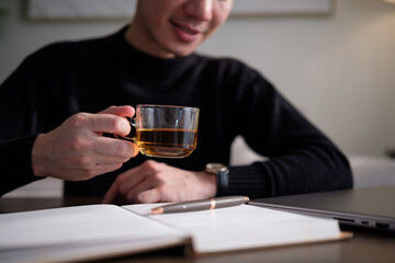 Tea break moment in a cozy home workspace, highlighting calm and focus.