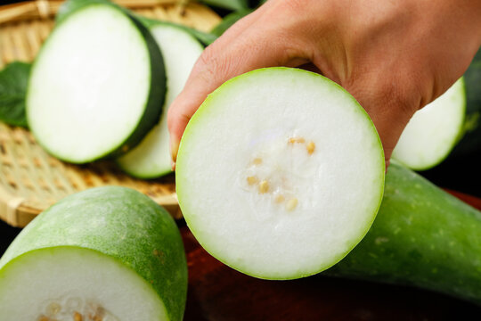 Fresh Winter Melon Slices with White Flesh and Seeds on Bamboo Background