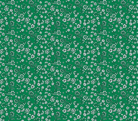 Simple ditsy floral seamless pattern with tiny white folk-style flowers on a green background. Cute and dense vintage print for textile, fabric, or wallpaper. Small botanical design.