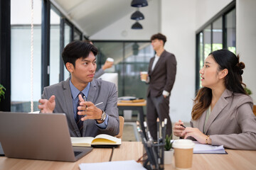 Business colleagues engaged in a serious conversation in a modern office space.