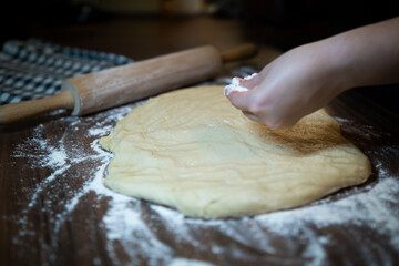 Baker preparing dough on kitchen table. Homemade pastry making process.