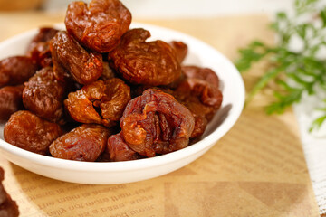 Dried Lychee Fruits from Fujian China in White Bowl - Traditional Asian Specialty Snack with Thick Cinnamon Colored Skin