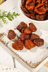 Mixed Dried Fruits on Rustic Wooden Board with Bowl and Herbs