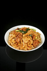 Stir-Fried Flat Rice Noodles with Crispy Pork and Vegetables in White Bowl