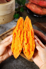 Fresh Cooked Sweet Potato Halves Held in Hands Showing Deep Orange Flesh and Natural Texture