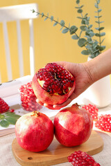 Fresh Pomegranate Half with Seeds in Hand - Healthy Fruit Kitchen Scene