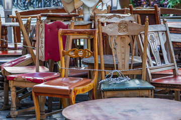 Collection of vintage wooden chairs in outdoor cafe