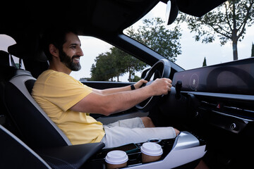 Happy tourist driving modern electric car during summer vacation in spain