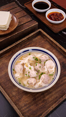 Homemade Wonton Soup with Meat Dumplings Served on Wooden Tray with Traditional Asian Condiments
