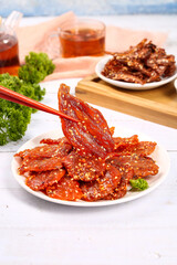Spicy Dried Fish Fillets Asian Seafood Snacks with Chopsticks and Tea