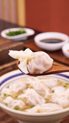 Fresh Homemade Wonton Soup with Meat Dumplings in Bowl on Wooden Spoon