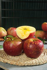 Fresh Daliangshan Red Apples on Wicker Basket with Cut Apple Showing Interior